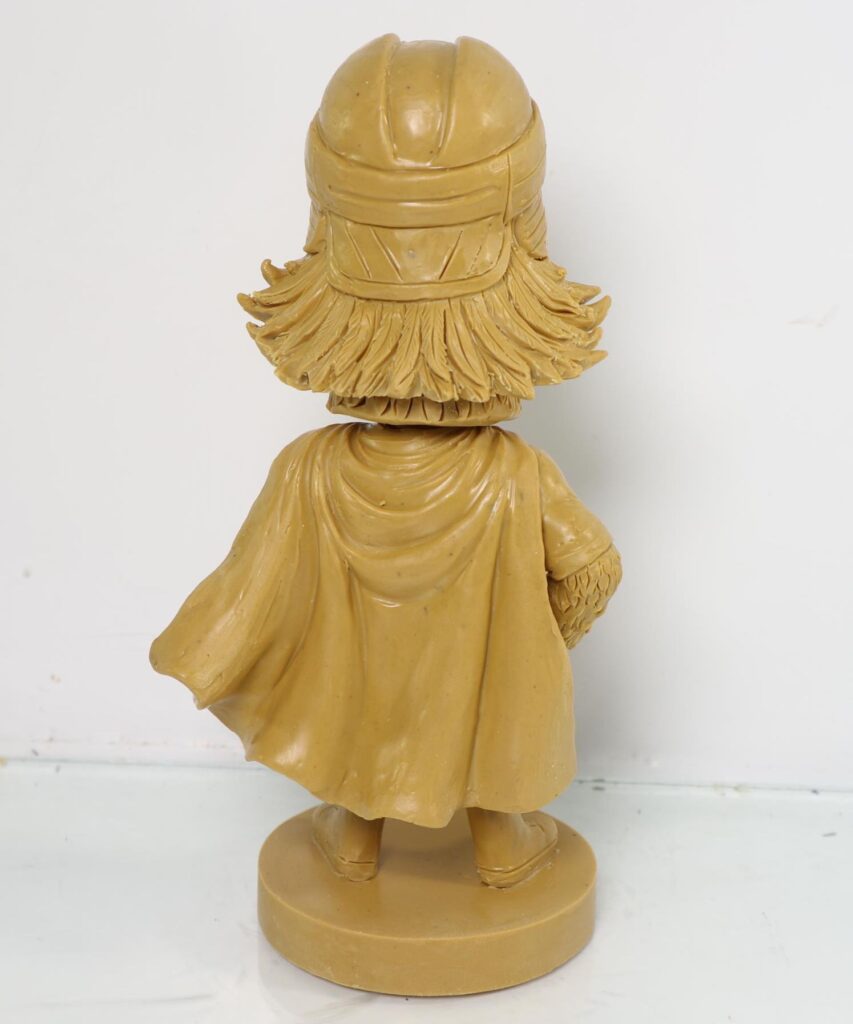 Back view of the pigeon mascot sculpture showing helmet and cape details